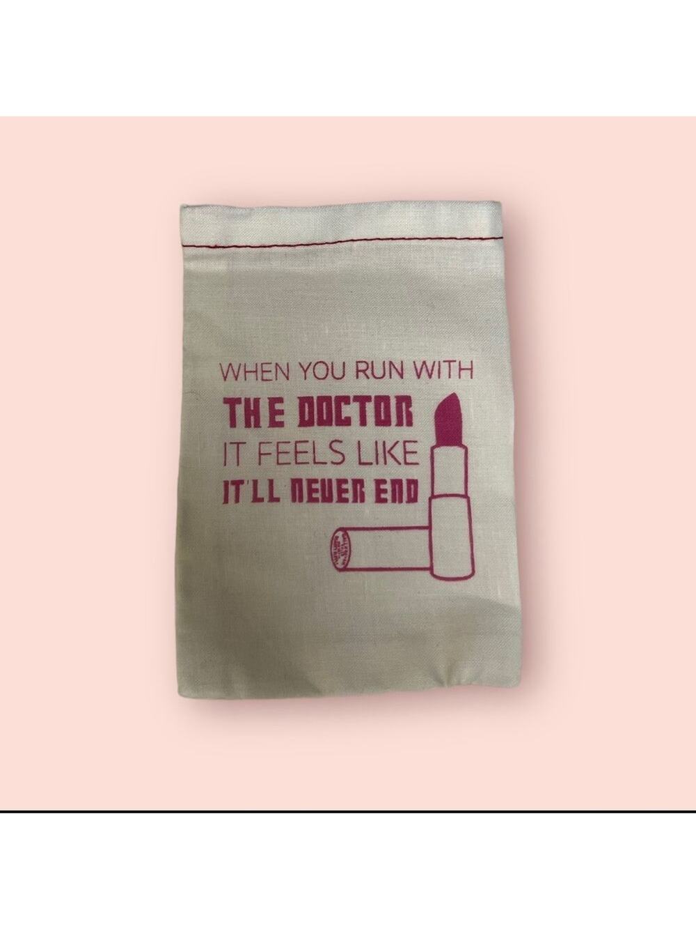 Dr. Who small white drawstring  cosmetic bag with pink writing.
